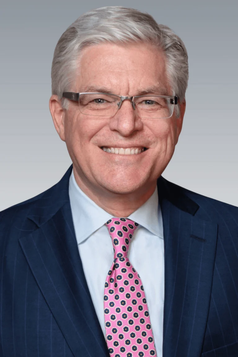 Retrato de Thomas E. Patterson, abogado profesional con vestimenta formal, de pie con confianza.