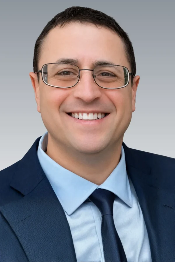Portrait of David Sanders, attorney in formal attire, standing confidently in a law office or courtroom setting.