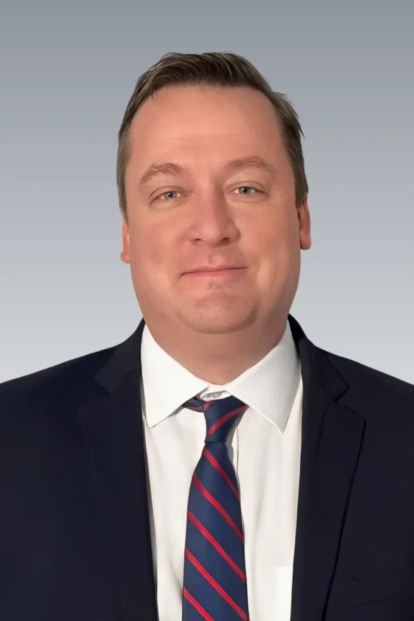 Portrait of Kevin F. Geary, attorney at law, in formal business attire, posed confidently in a legal office or courtroom setting
